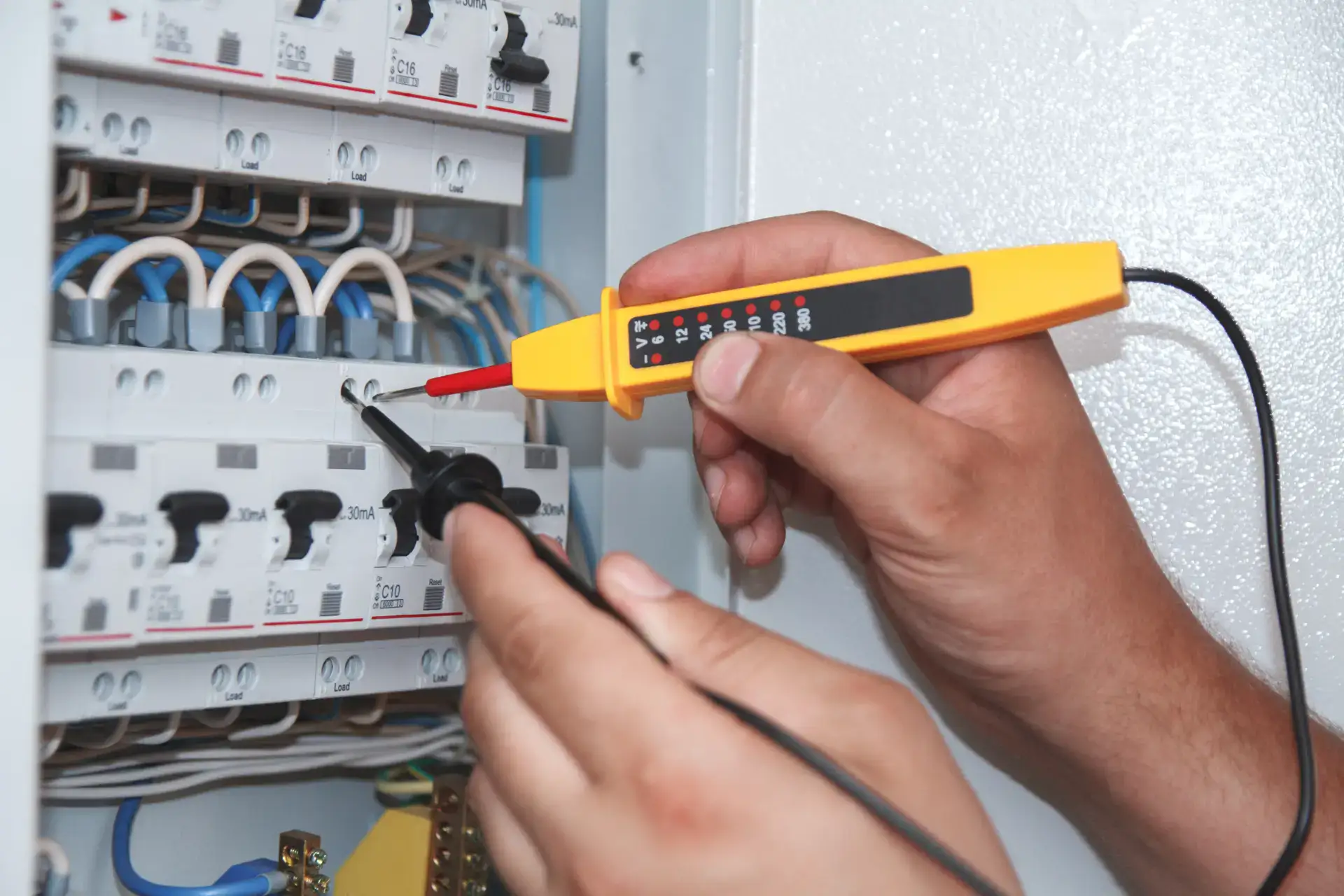 Elektriker bruger multimeter til at teste elektrisk kredsløb.